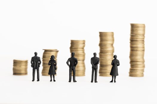 Group of figurines looking at growing stacks of coins. Business or finance growth concept. Copy space